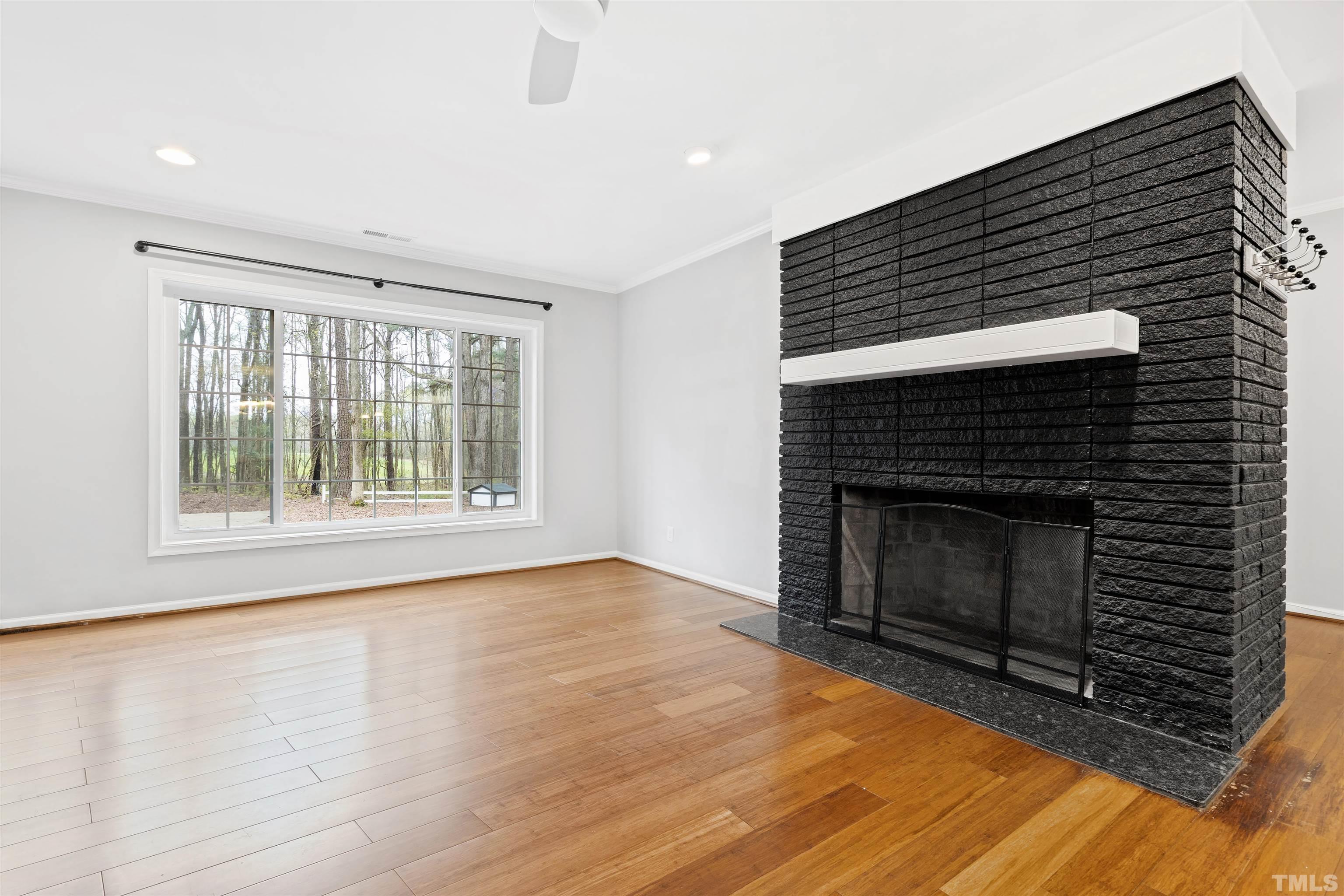 2528 Optimist Farm Road Apex, NC 27539 - Photo 10 of 49 a view of an empty room with wooden floor fireplace and a window