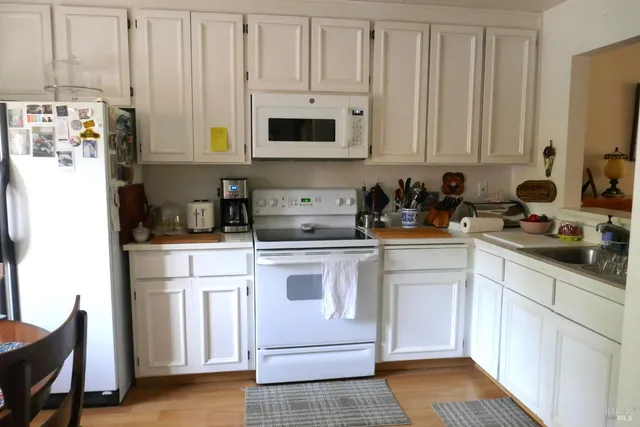 a kitchen with stainless steel appliances white cabinets and a refrigerator