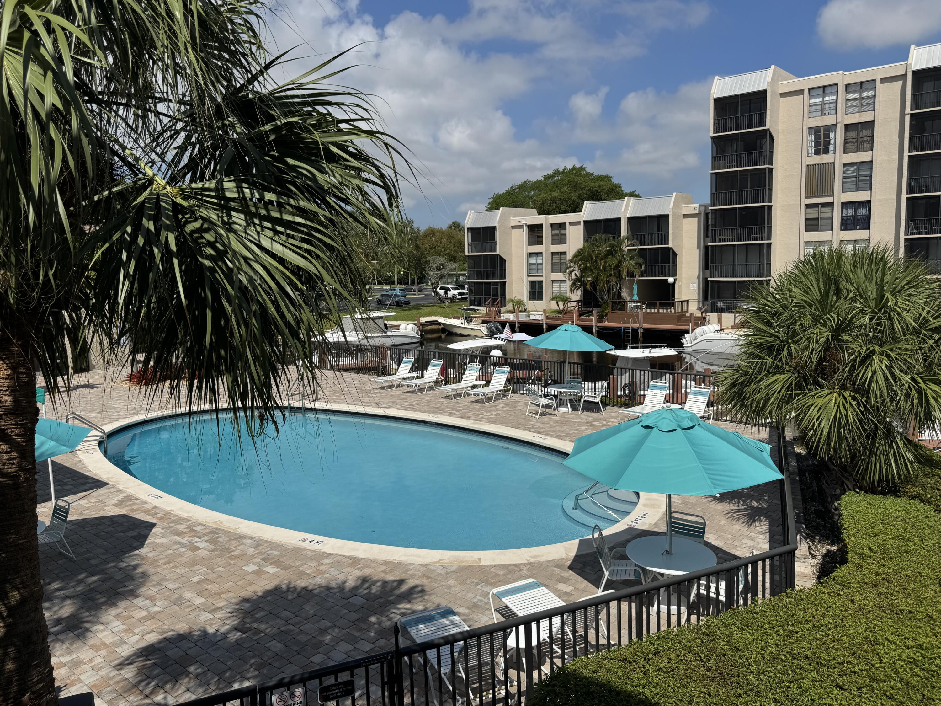 6 Royal Palm Way, Unit 202 Boca Raton, FL 33432 - Photo 23 of 29 a view of a swimming pool and chairs in patio
