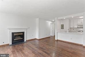 20979 Timber Ridge Terrace, Unit 101 Ashburn, VA 20147 - Photo 8 of 16 a view of an empty room and kitchen with fireplace