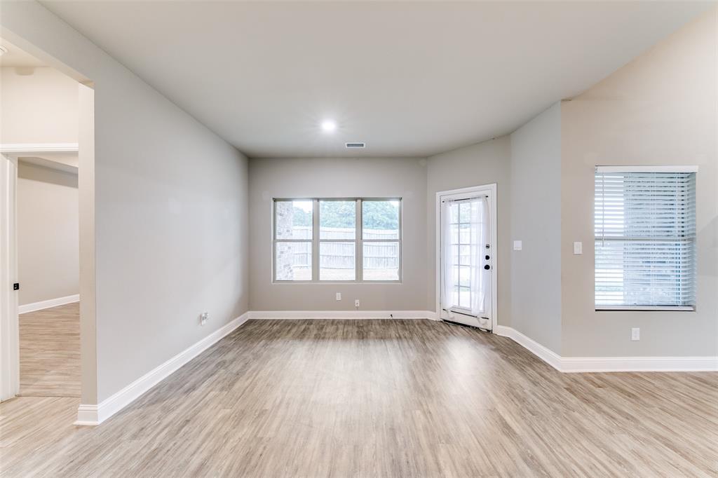 2844 Rodeo Drive Quinlan, TX 75474 - Photo 12 of 25 an empty room with wooden floor and windows
