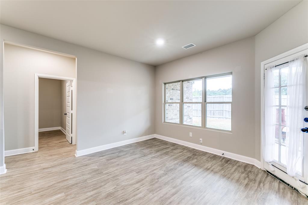 2844 Rodeo Drive Quinlan, TX 75474 - Photo 13 of 25 an empty room with wooden floor and windows