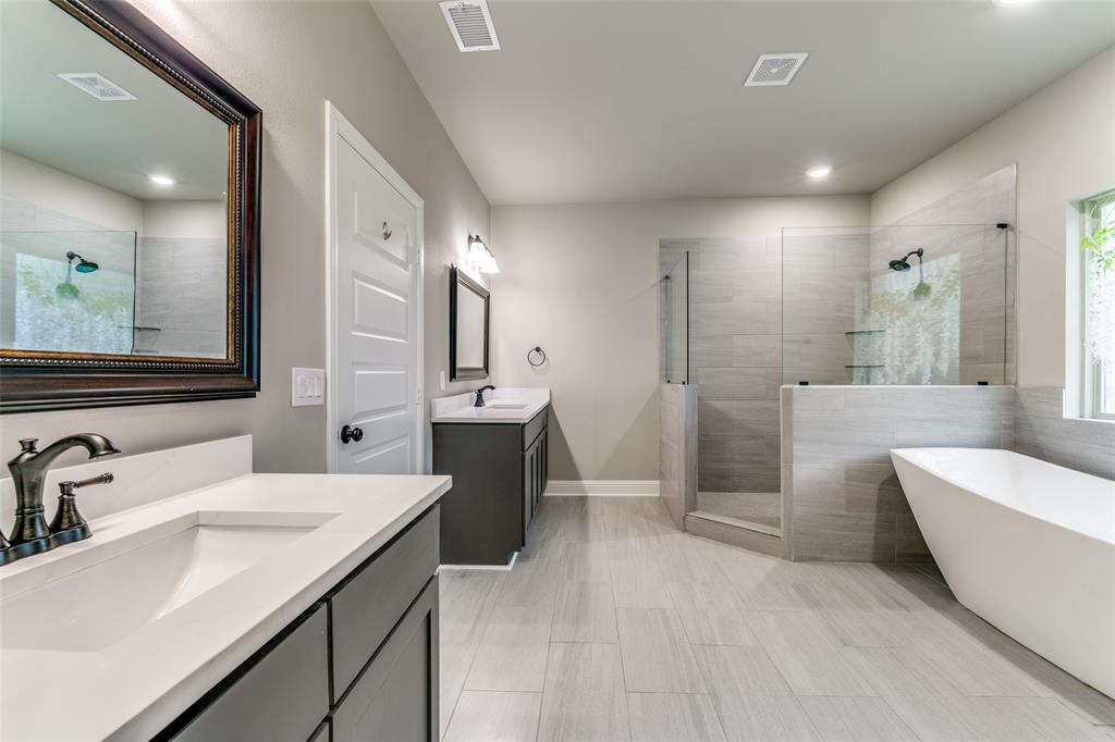 2844 Rodeo Drive Quinlan, TX 75474 - Photo 16 of 25 a large bathroom with a double vanity sink a mirror and a shower