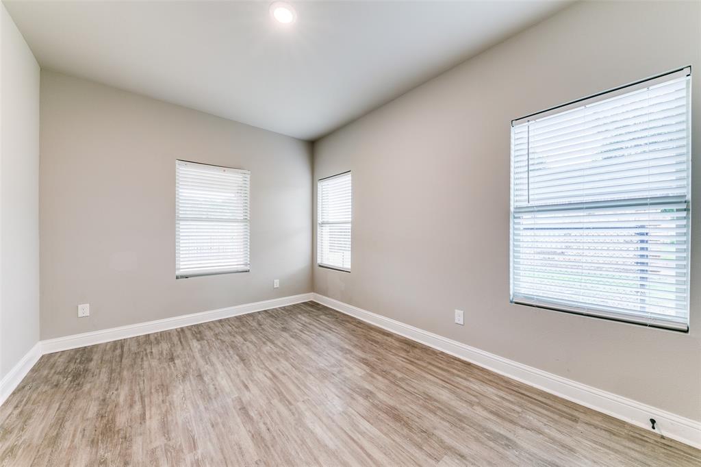 2844 Rodeo Drive Quinlan, TX 75474 - Photo 17 of 25 an empty room with wooden floor and windows