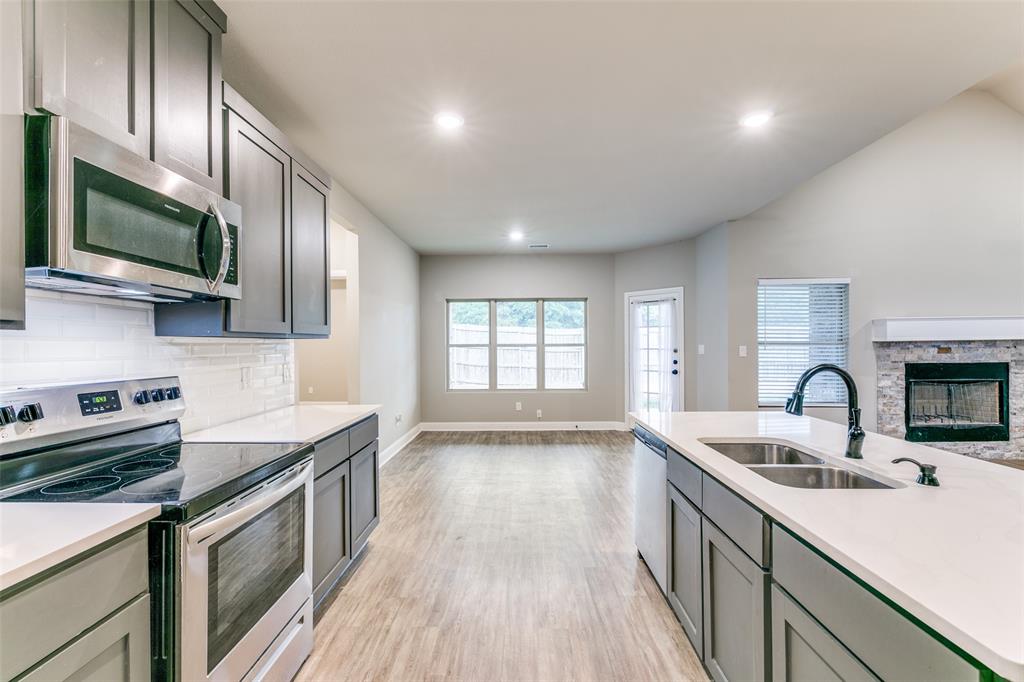 2844 Rodeo Drive Quinlan, TX 75474 - Photo 8 of 25 a kitchen with a sink a stove and cabinets
