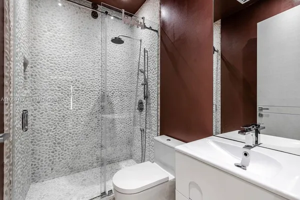a bathroom with a sink a toilet and shower