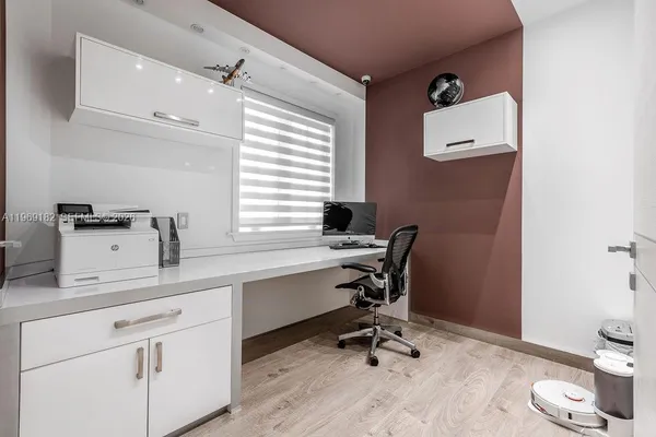 a view of a workspace with furniture and a window