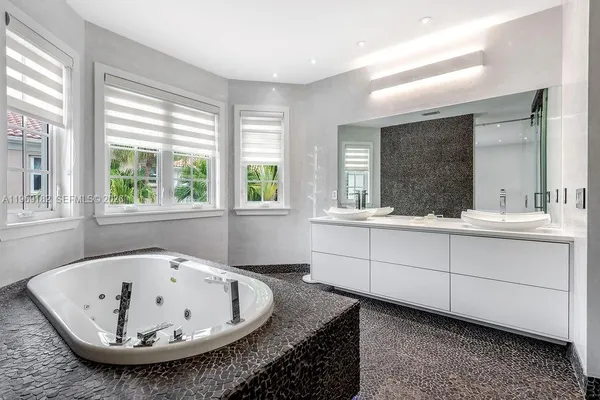 a bathroom with a tub sink and mirror