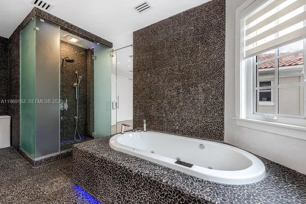 a bathroom with a granite countertop bathtub and shower