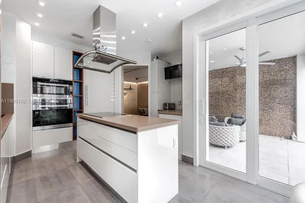 a kitchen with stainless steel appliances kitchen island granite countertop a refrigerator and a stove