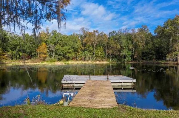 a backyard of a house with lots of green space and lake view