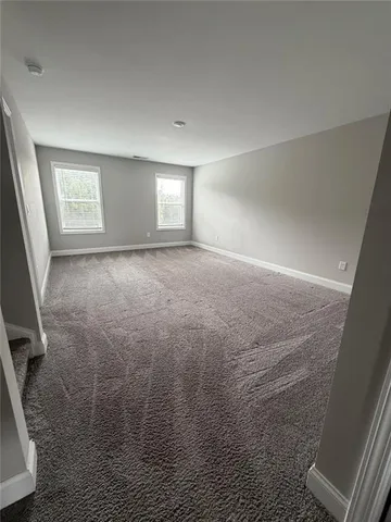 en empty room with windows and fan