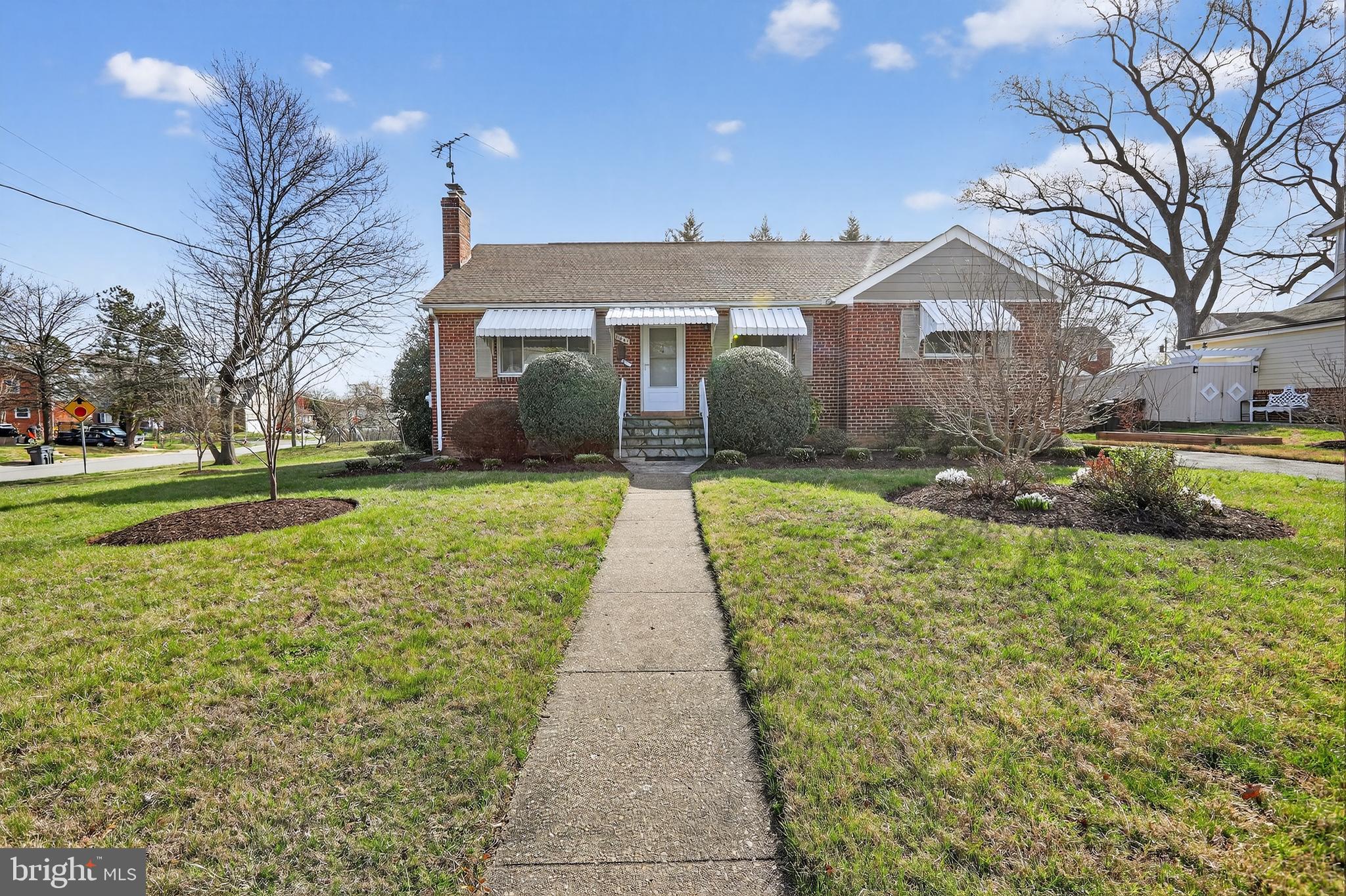a front view of a house with a yard and trees