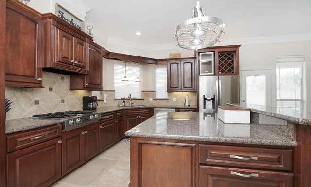 a kitchen with stainless steel appliances granite countertop a stove refrigerator a sink and dishwasher