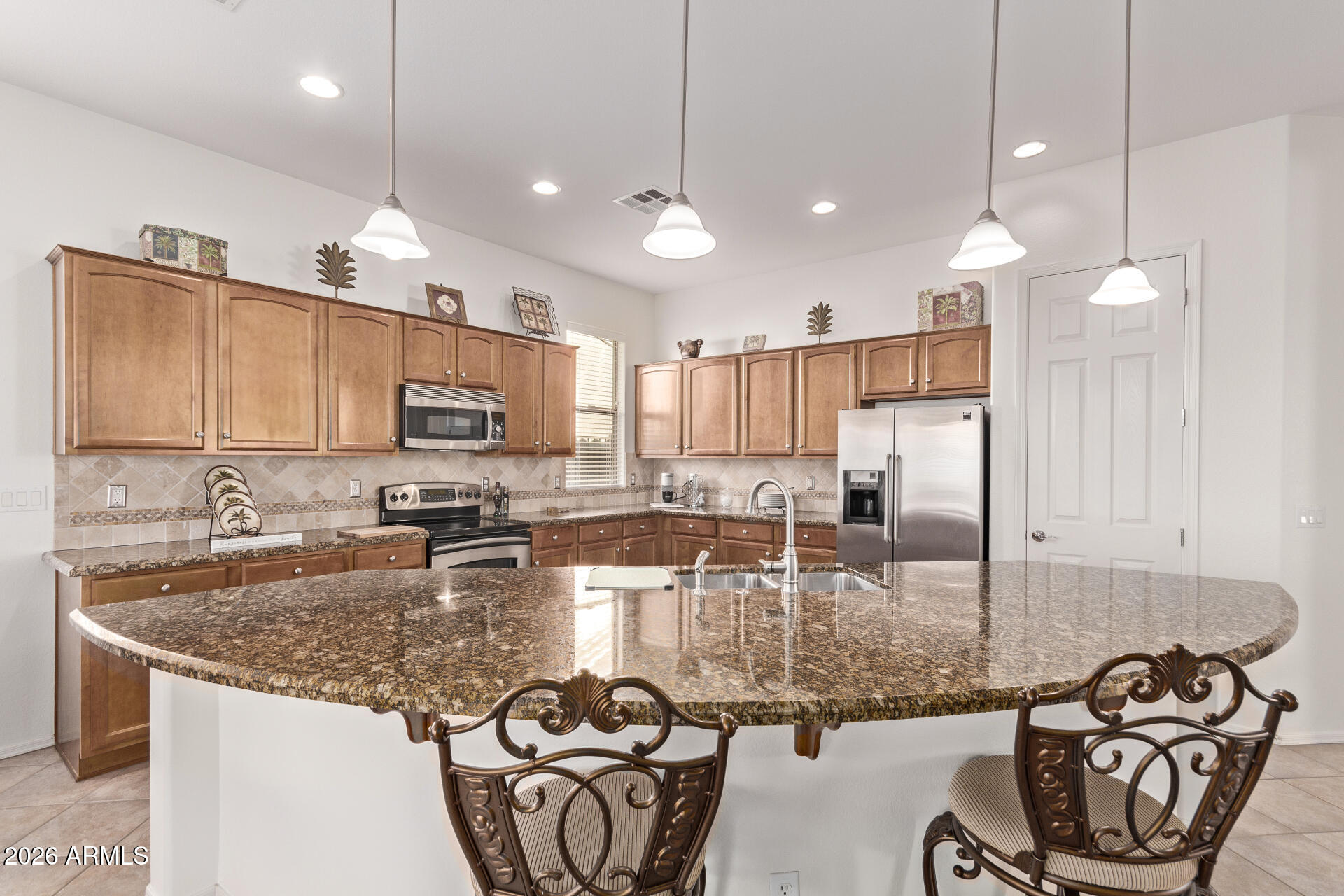 4120 East Jude Lane Gilbert, AZ 85298 - Photo 14 of 61 a kitchen with granite countertop kitchen island stainless steel appliances a sink a stove a microwave a center island and cabinets