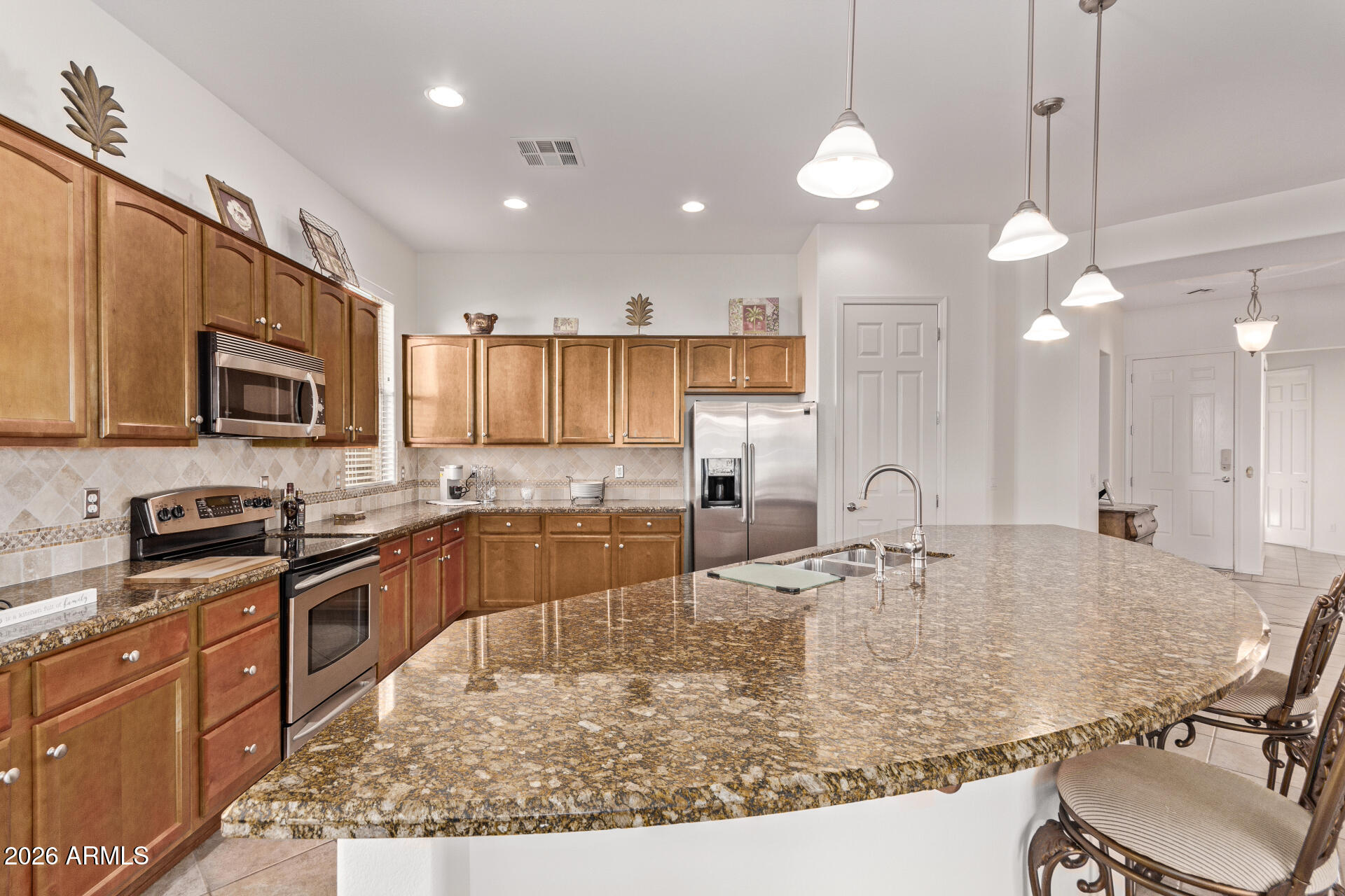 4120 East Jude Lane Gilbert, AZ 85298 - Photo 15 of 61 a large kitchen with kitchen island a stove a sink a center island a dining table and chairs