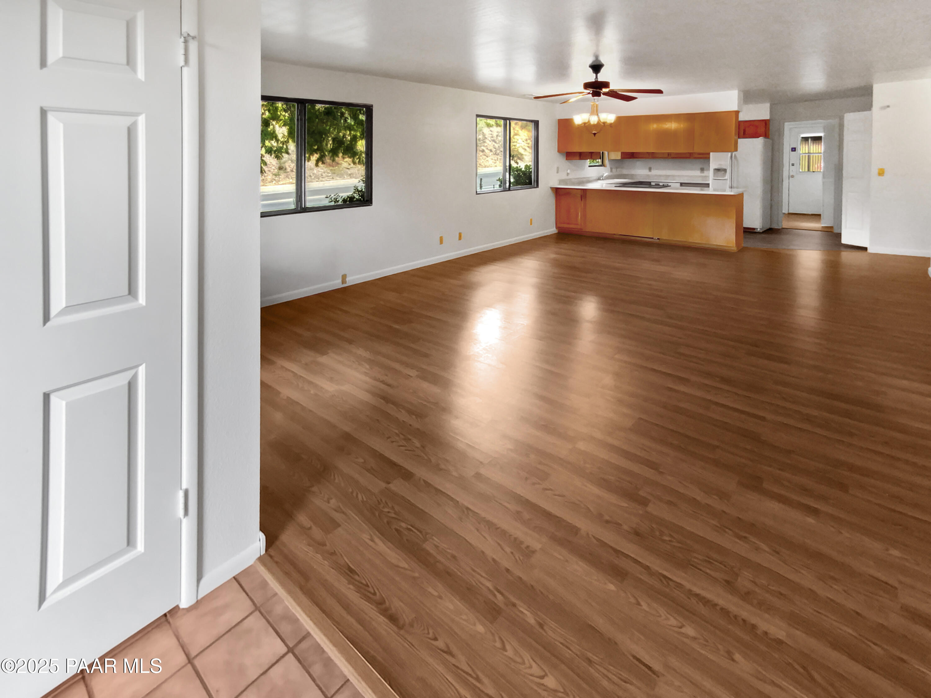 410 Apache Plume Trail Prescott, AZ 86301 - Photo 9 of 22 an empty room with wooden floor windows and kitchen view