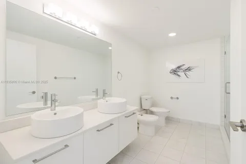 a bathroom with a double vanity sink mirror and toilet