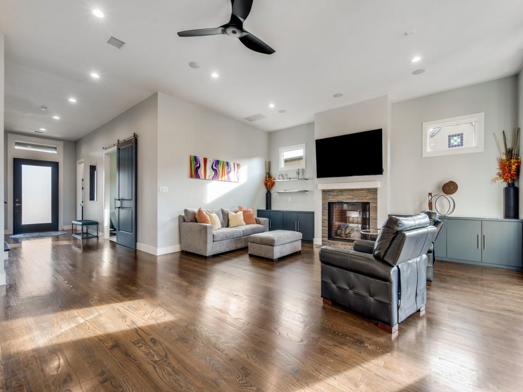 7912 Hanover Street Dallas, TX 75225 - Photo 5 of 25 Living room with a ceiling fan, wood finished floors, a barn door, recessed lighting, and a stone fireplace