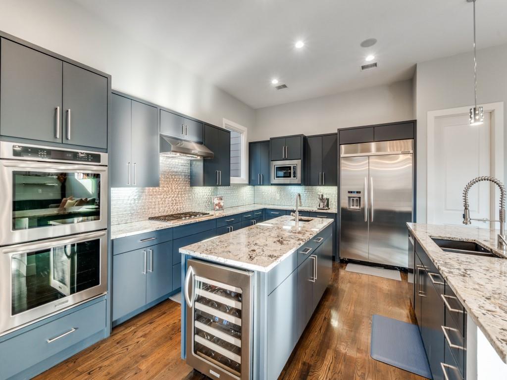 7912 Hanover Street Dallas, TX 75225 - Photo 8 of 25 Kitchen with built in appliances, hanging light fixtures, a kitchen island with sink, wine cooler, and light stone counters