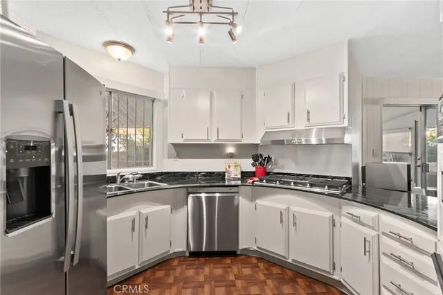 a kitchen with stainless steel appliances granite countertop a sink and cabinets