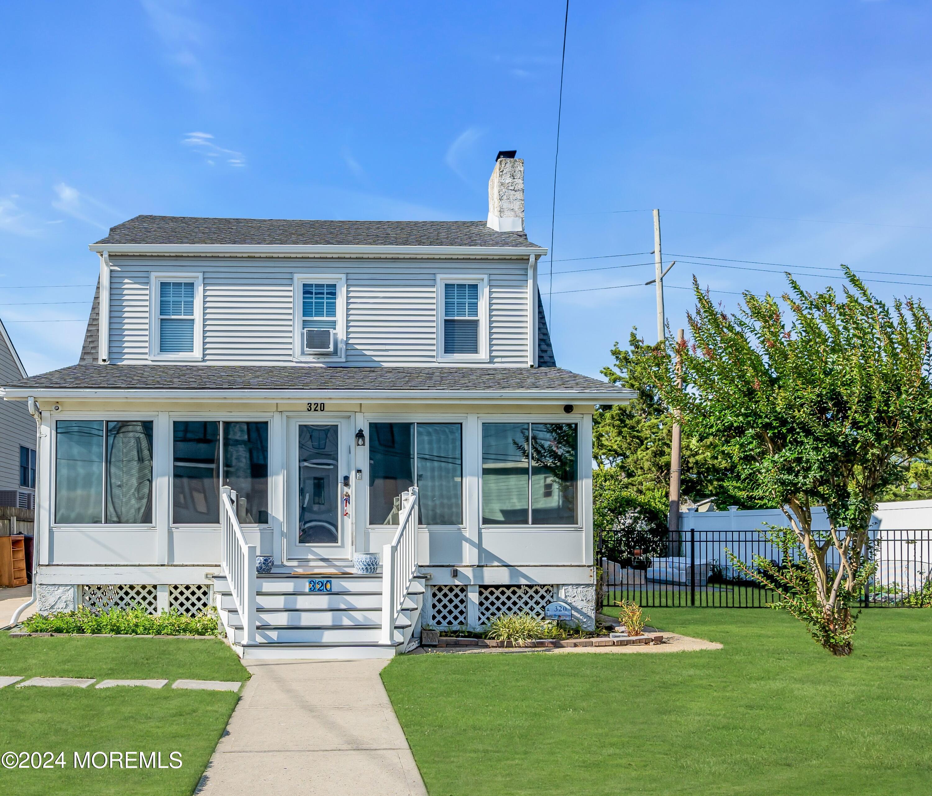 a front view of a house with a garden and plants