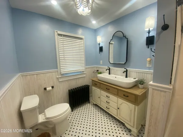 a bathroom with a toilet sink and mirror