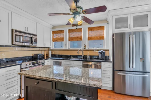 a kitchen with stainless steel appliances granite countertop a stove and a refrigerator