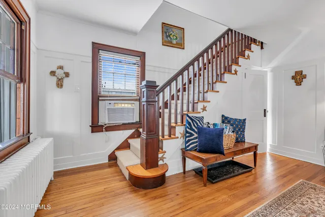 a living room with wooden floor and a potted plant