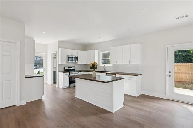a kitchen with stainless steel appliances granite countertop a stove a sink dishwasher and a refrigerator