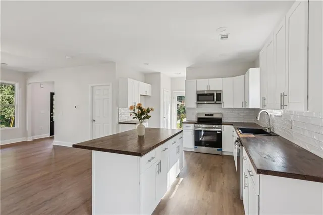 a kitchen with granite countertop a sink a stove and wooden floor