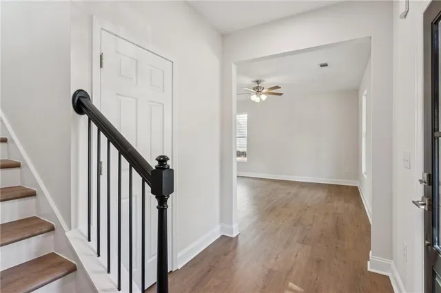 a view of a hallway with wooden floor and staircase