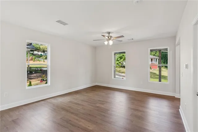 an empty room with wooden floor and window