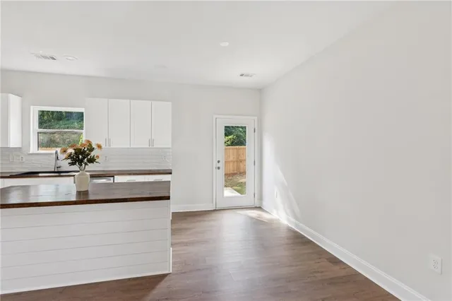a kitchen with white cabinets and appliances