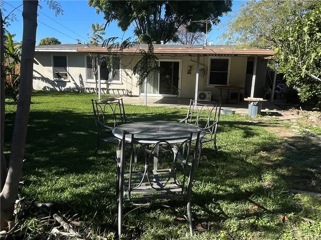 a view of a chair and table in backyard of the house