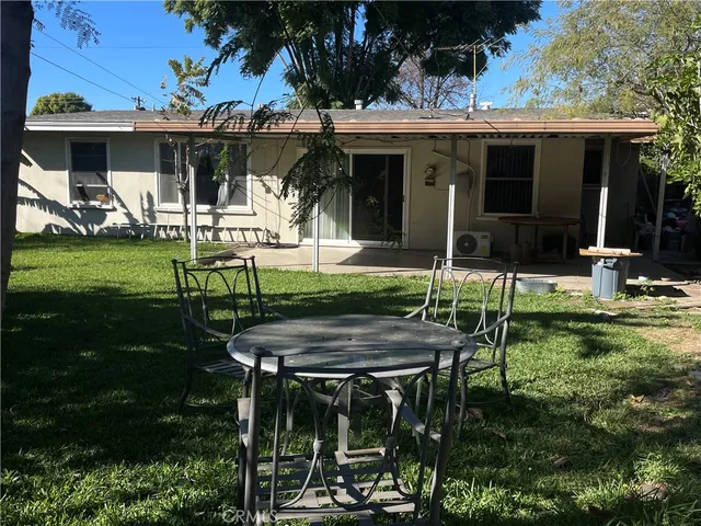 a view of a chairs and table in backyard of the house