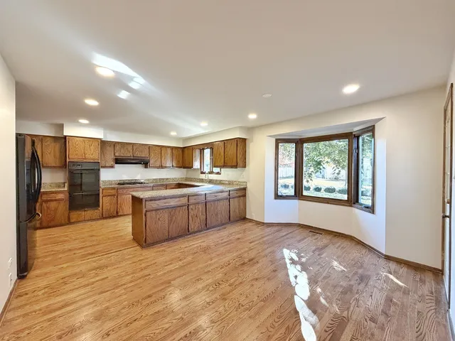 a large kitchen with a stove top oven and refrigerator