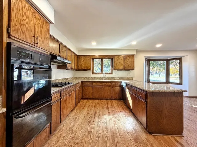 a large kitchen with stainless steel appliances granite countertop a stove a sink and a refrigerator