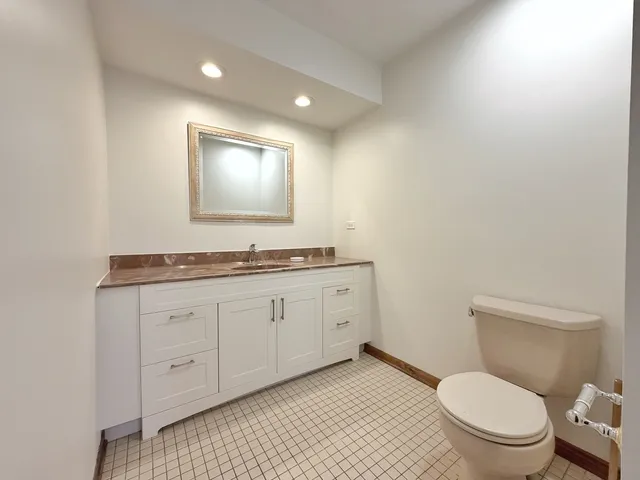 a bathroom with a granite countertop toilet a sink and a mirror