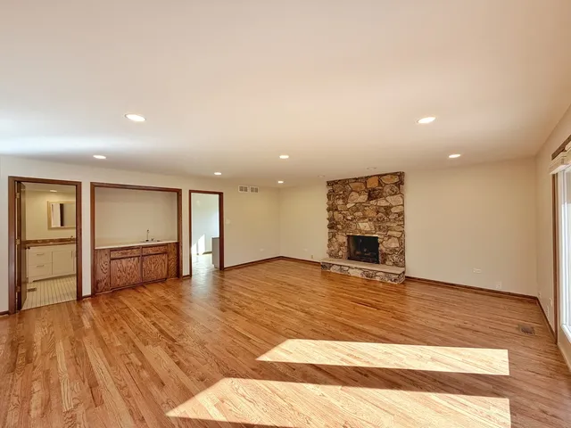 a view of empty room with wooden floor and window