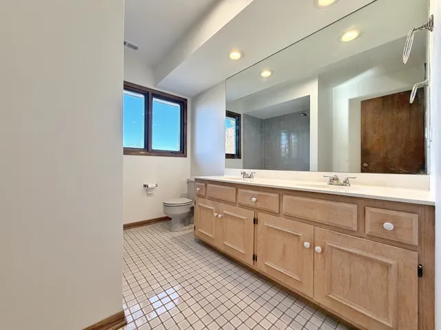 a spacious bathroom with a double vanity sink and a mirror
