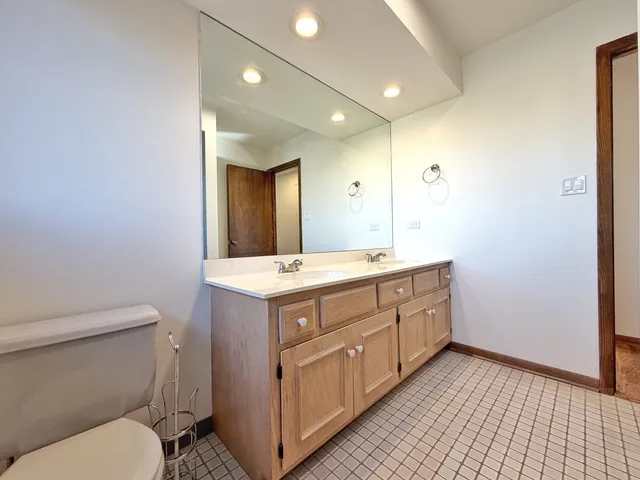 a bathroom with a double vanity sink toilet and a mirror