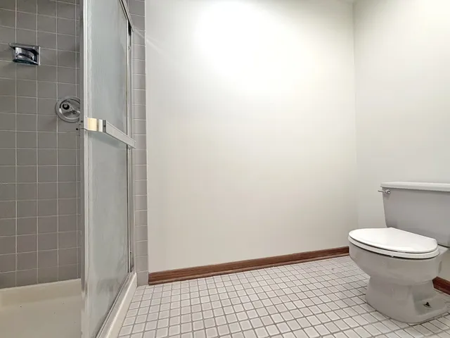 a bathroom with a toilet and a shower