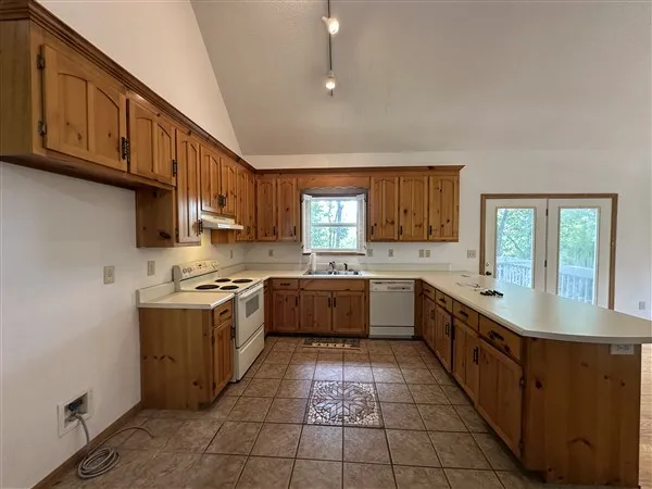 a kitchen with stainless steel appliances granite countertop a stove a sink dishwasher and a refrigerator