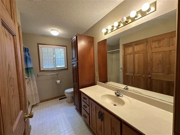 a spacious bathroom with a double vanity sink a large mirror and a shower