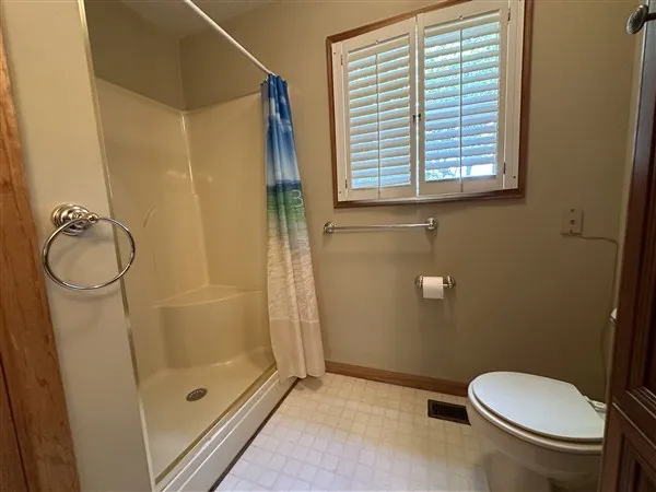 a bathroom with a granite countertop toilet and a shower