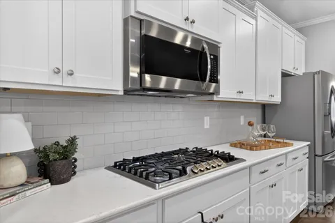 a kitchen with stainless steel appliances a stove a microwave a sink and cabinets