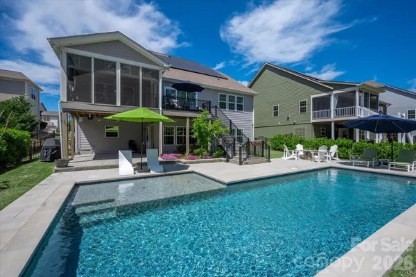a view of a house with swimming pool and sitting area
