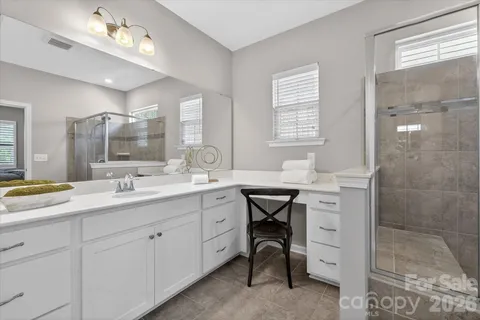 a bathroom with a sink double vanity granite tub shower and a mirror