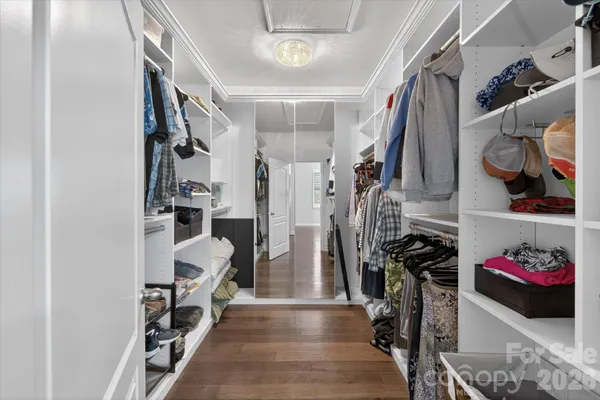 a view of walk in closet with clothes and shoes